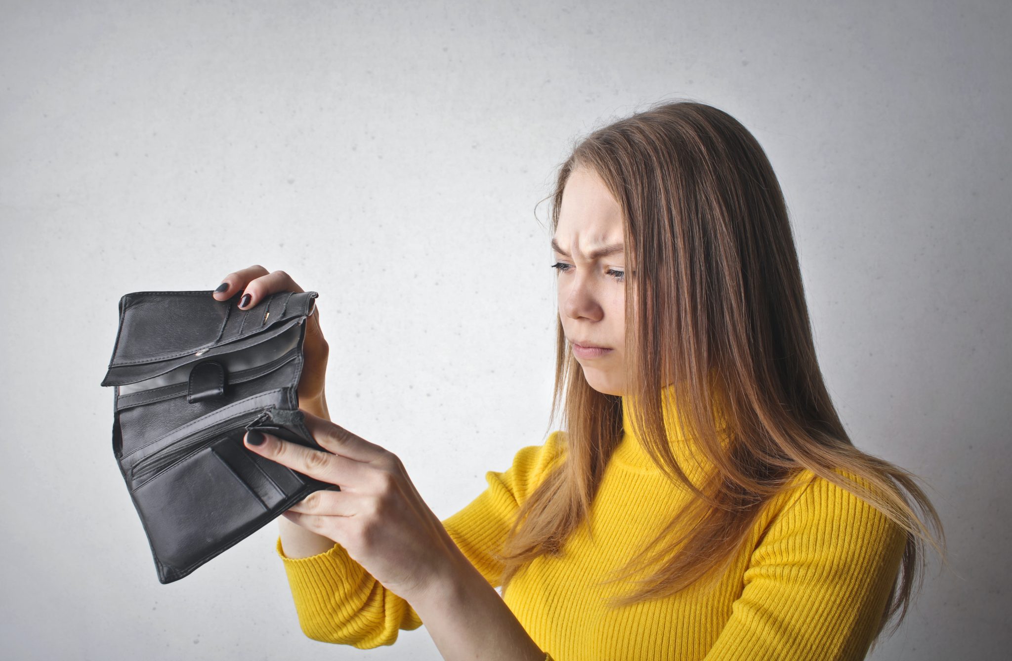 woman looking at empty wallet