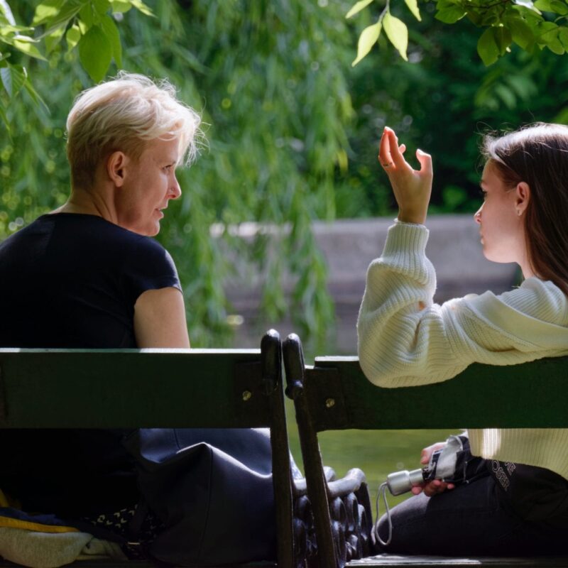Mother and daughter talking in a garden