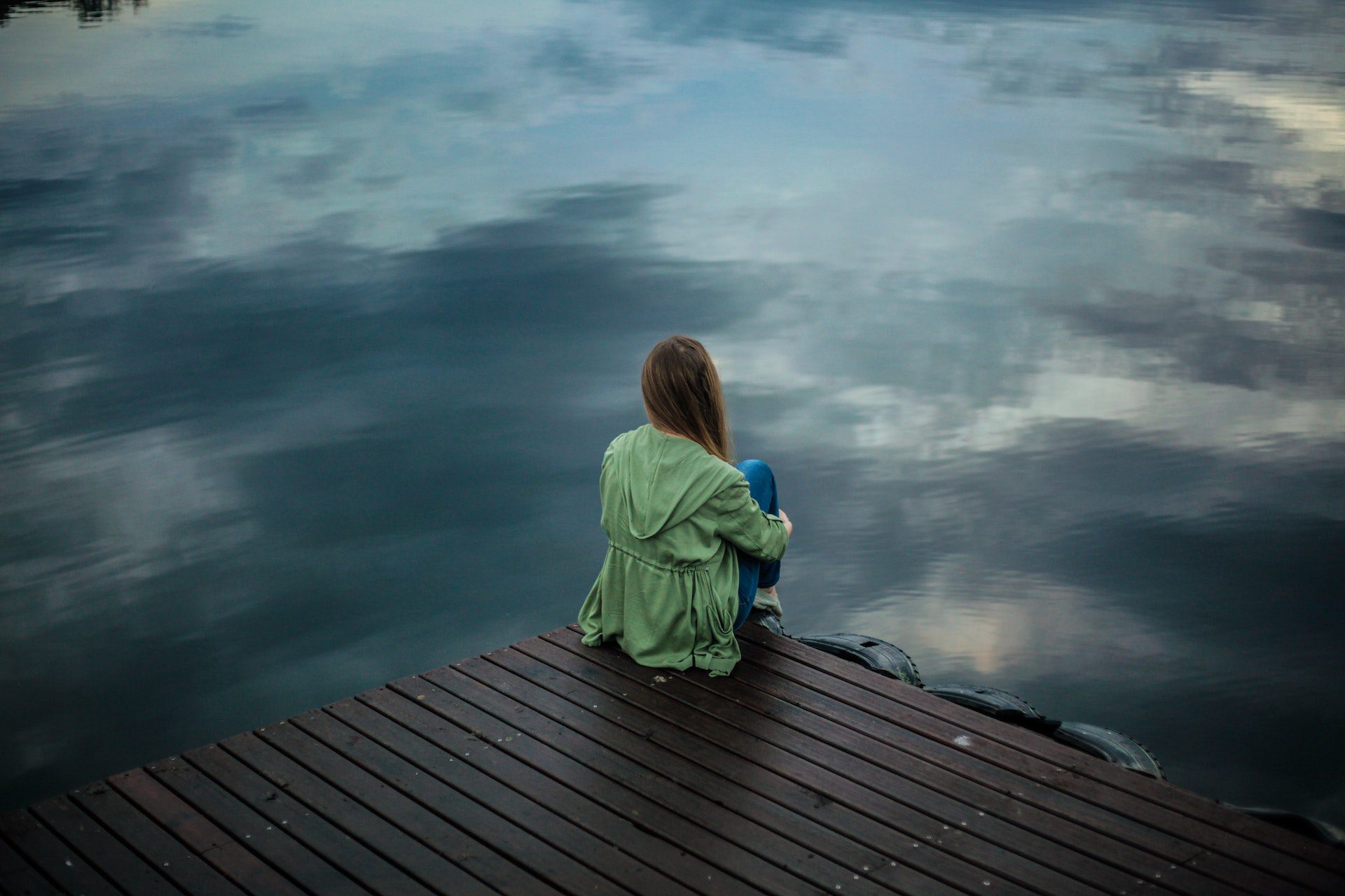 Woman Sitting on Wooden Planks over water