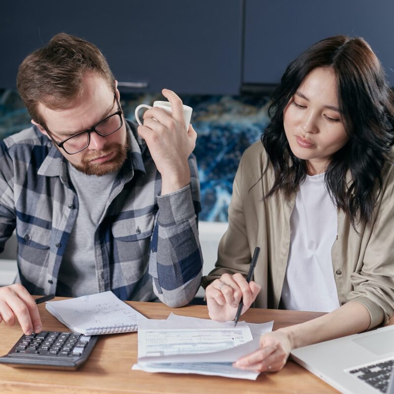 two people budgeting and using a calculator