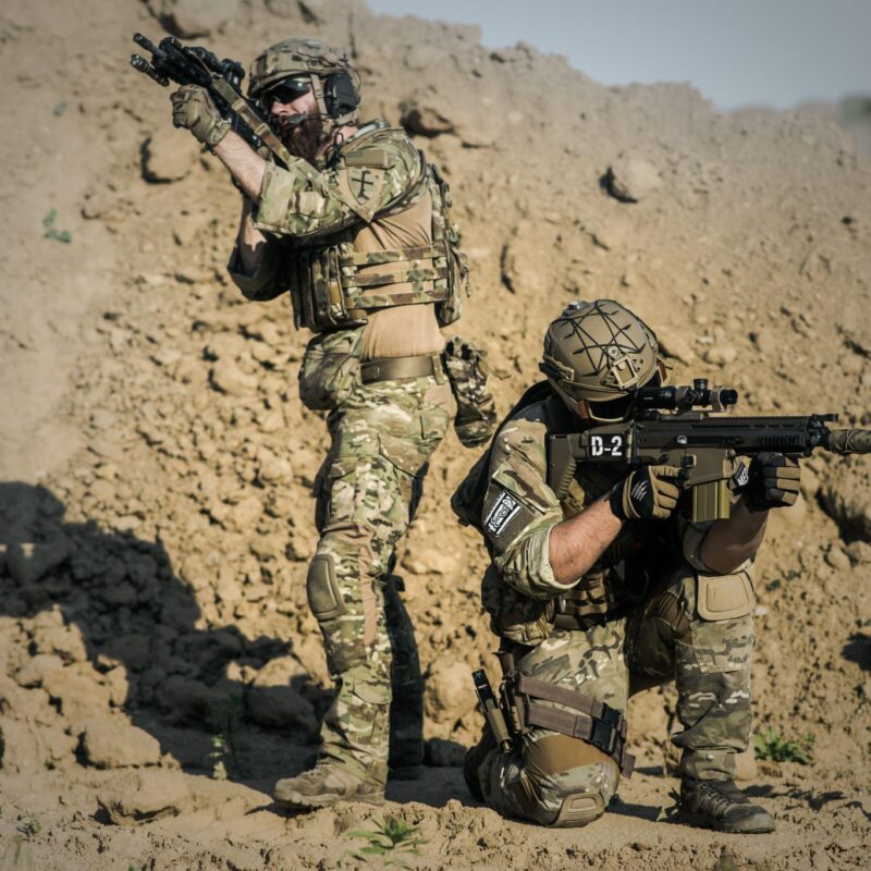 Two men in army uniforms with guns