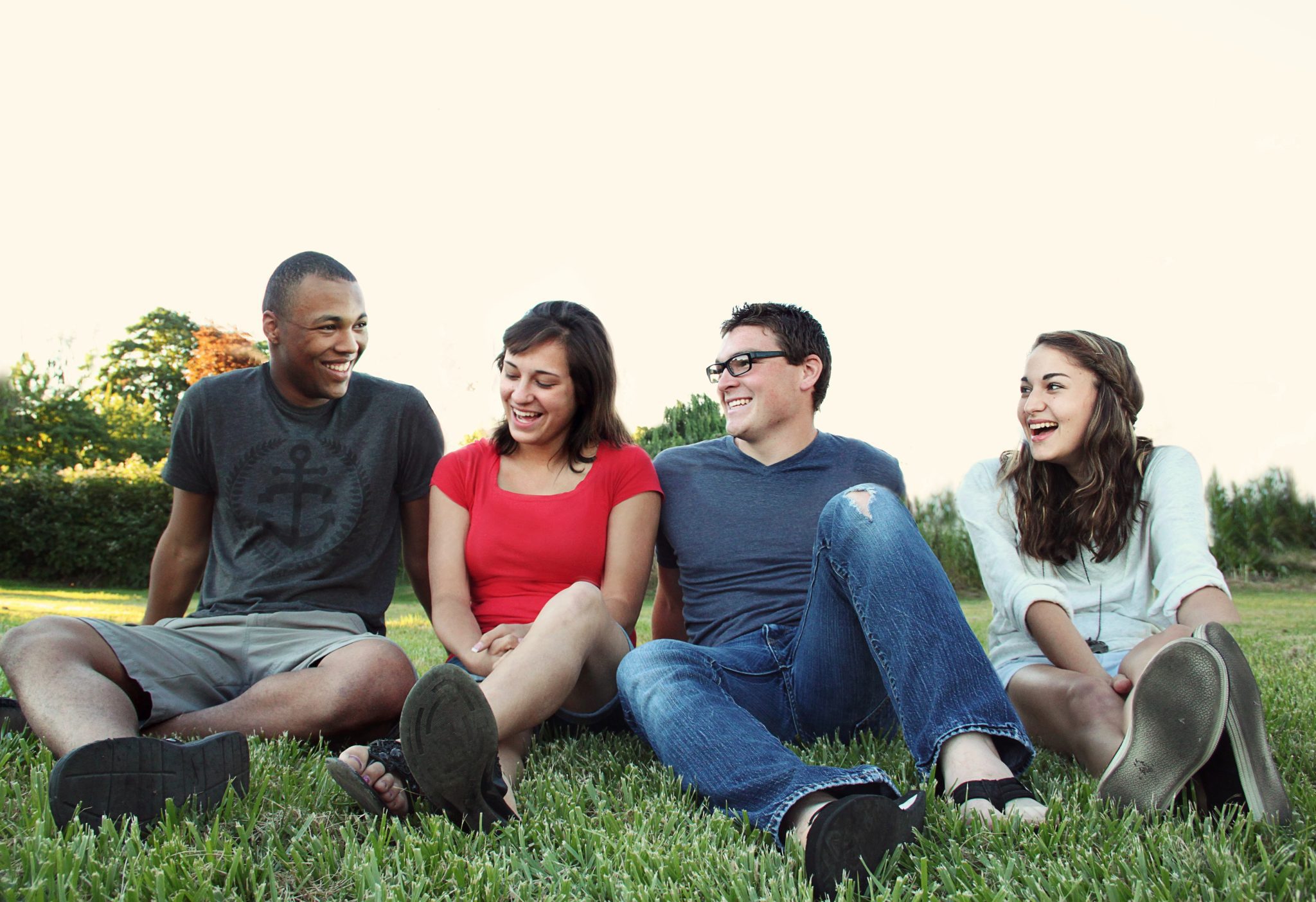 Four young people sitting on grass
