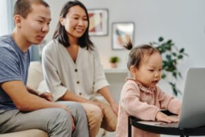 Family watching toddler on laptop