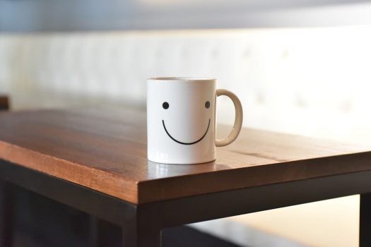 Mug with smiley face sitting on table