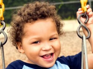 happy young boy on a playground swing