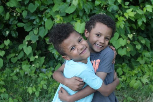 Two young siblings embracing