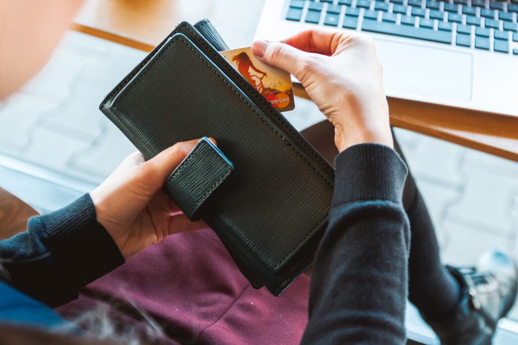 A woman holding a wallet while removing a credit card.