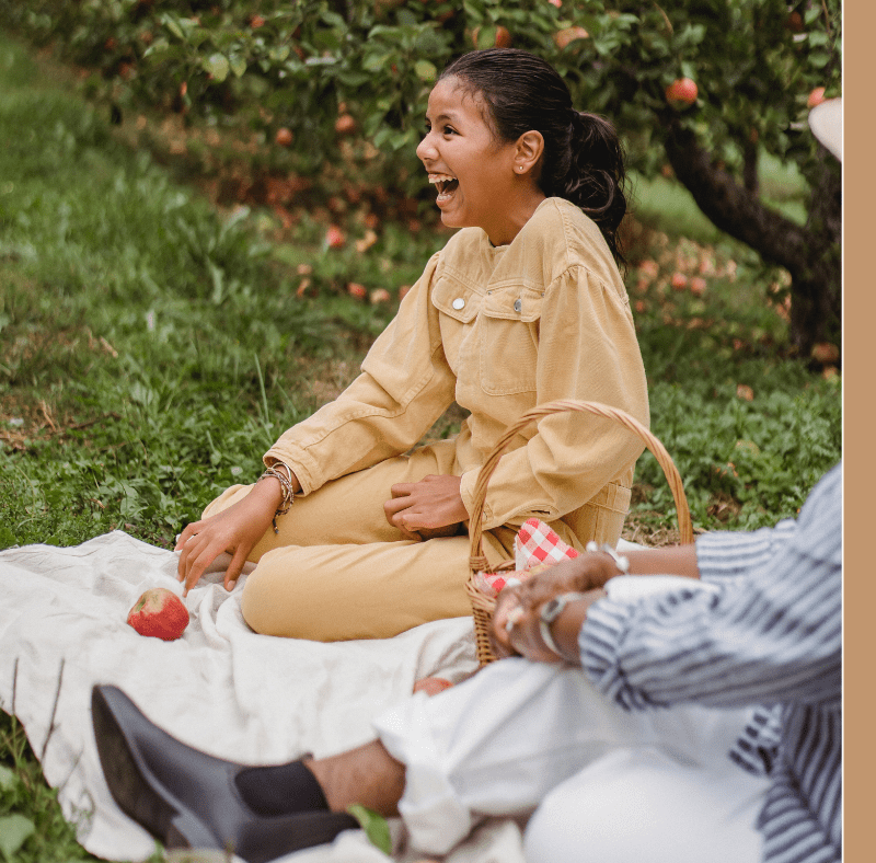 Young girl happy on picnic blanket outside