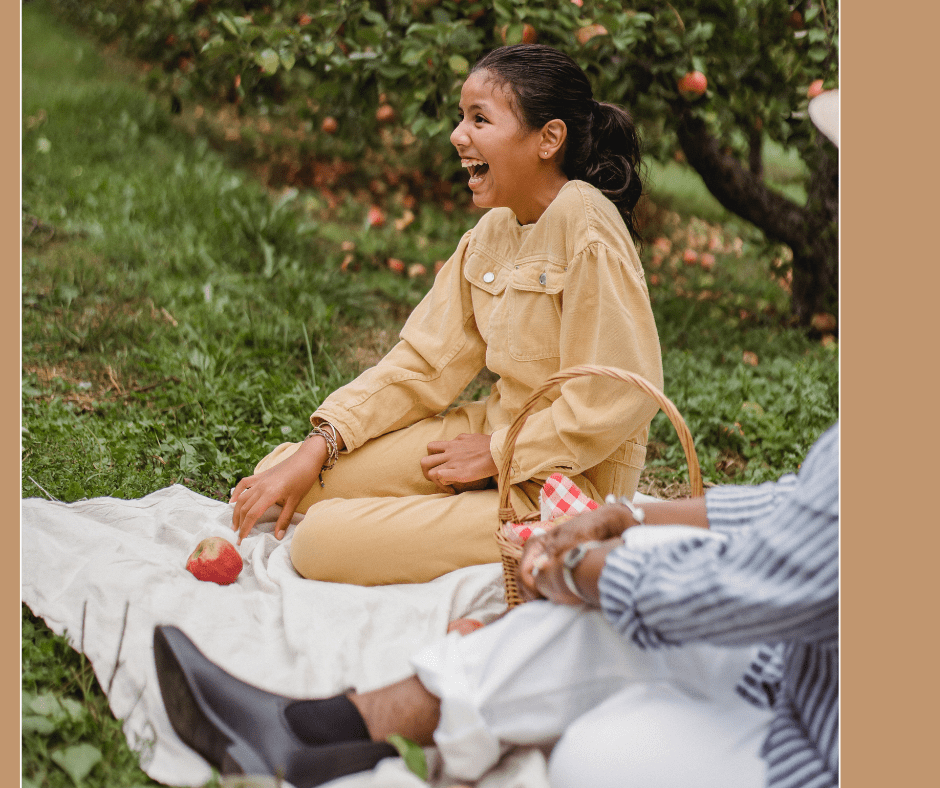 Young girl happy on picnic blanket outside