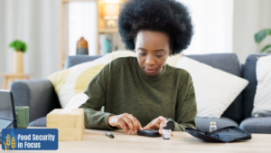 African-American woman checking blood sugar with glucometer.