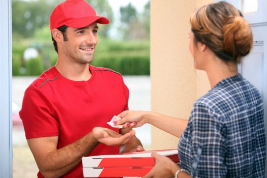 Woman handing money to man delivering pizza