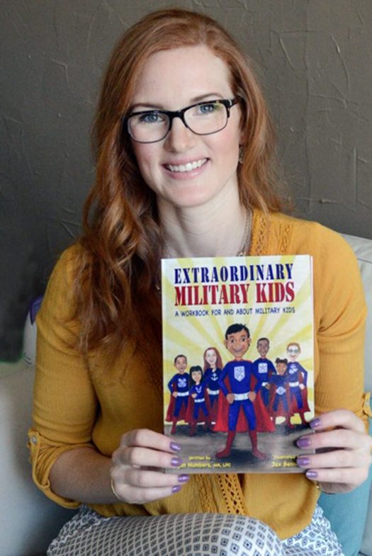 Megan Numbers holding a copy of Extraordinary Military Kids