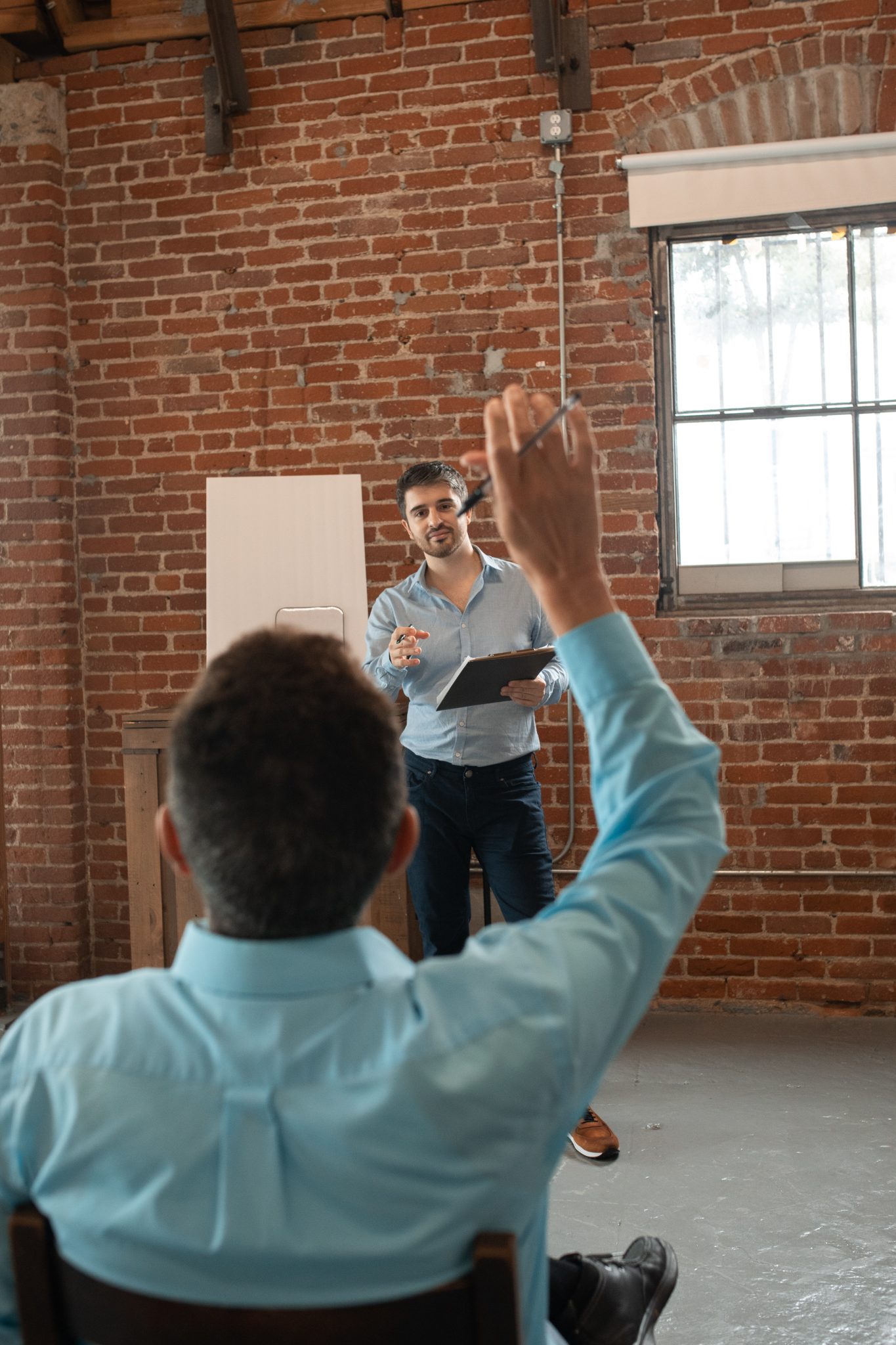 man standing calling on person with hand raised