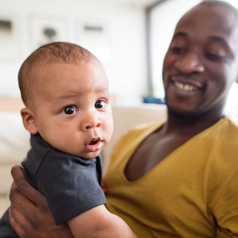 Image of young black father holding his infant son