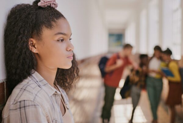 Sad teenage girl alone in a school hallway|Dr. Dale Blyth Head Shot|Dr. Kate Walker Head Shot
