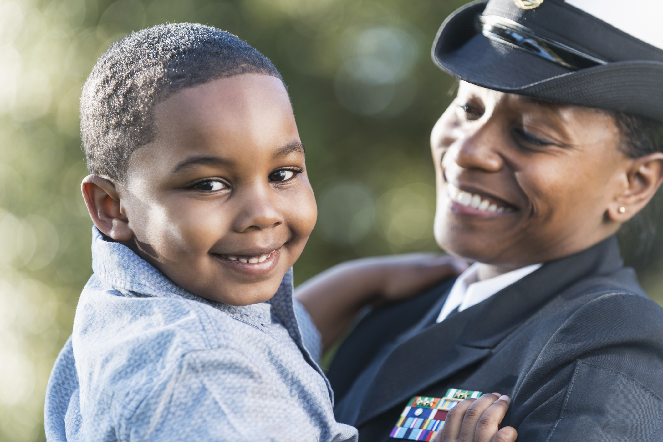 a military officer holds her son in her arms