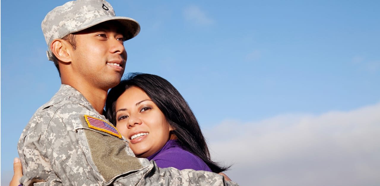 Military service member hugs military spouse in appreciation