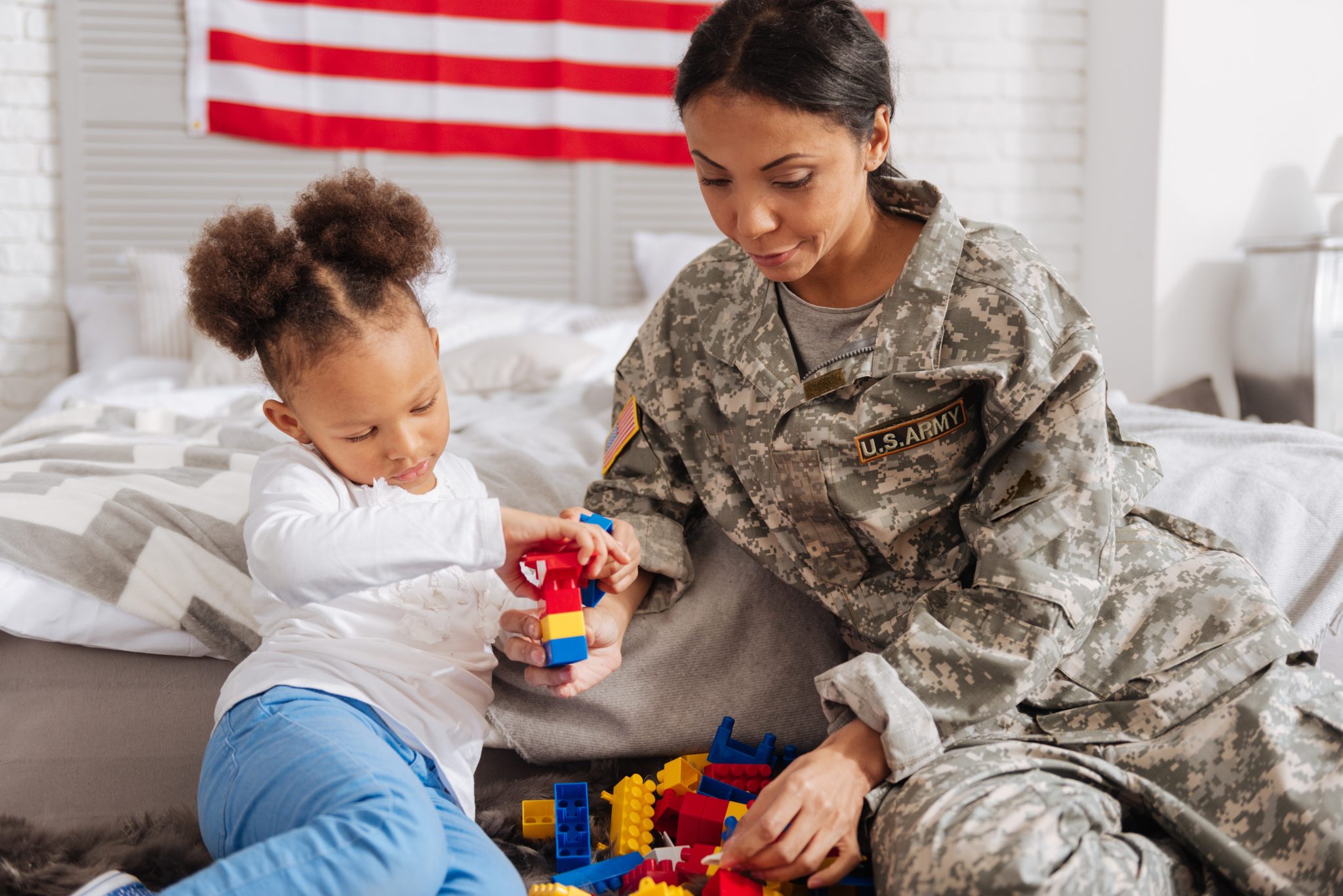 Service member and child build building blocks on iStock tocether.