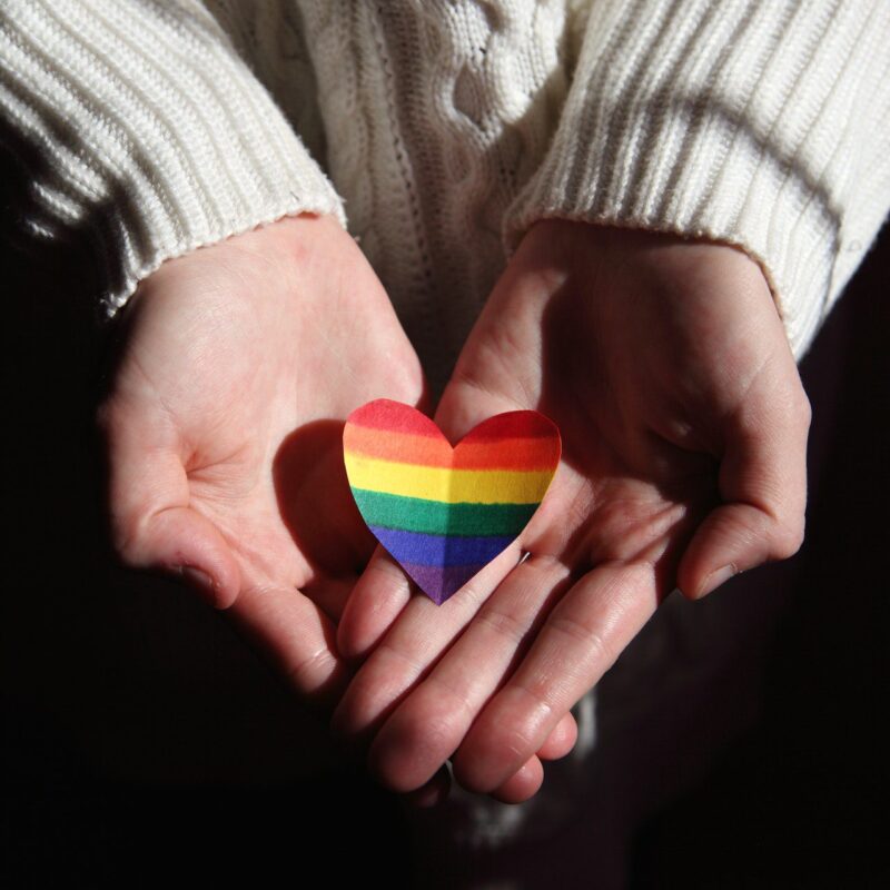 Person Holding Multi Colored Heart Shaped Ornament in their hands