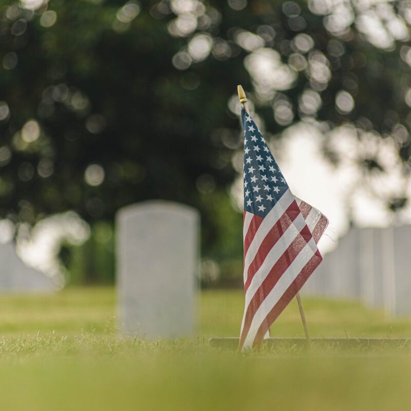 American Flag in grass in a graveyard