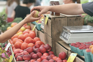 Customer purchasing produce at market.