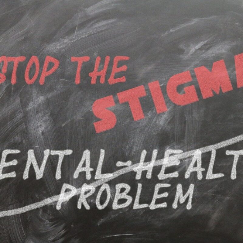 Chalk board with Stop the Stigma written on it, and mental health problem crossed out