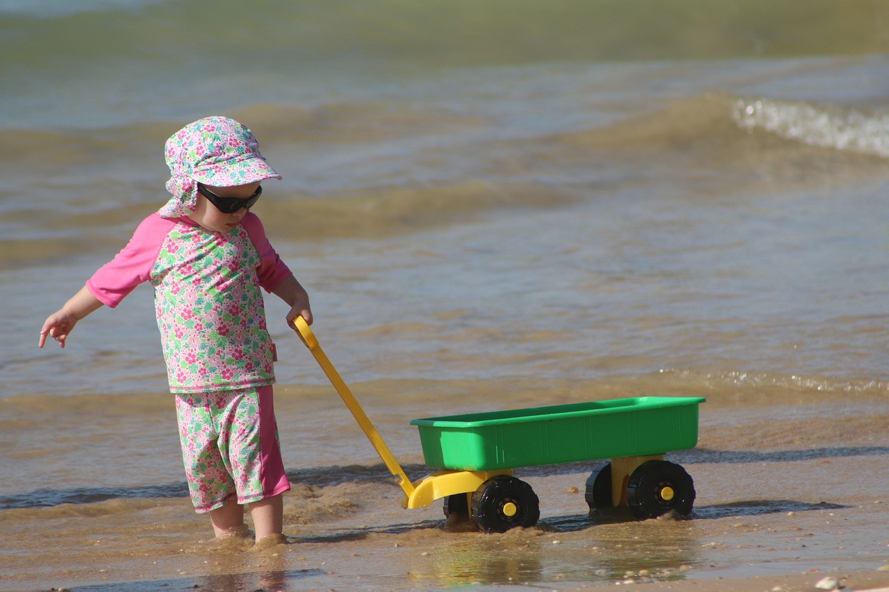 young child pulling a wagon on the beach