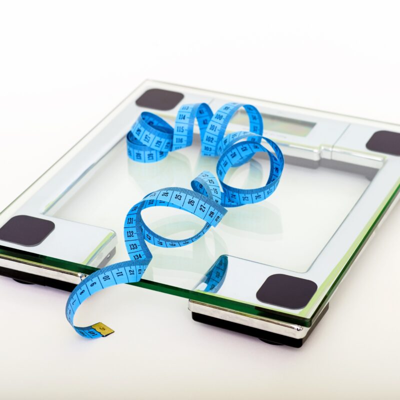 Digital scale with blue measuring tape.
