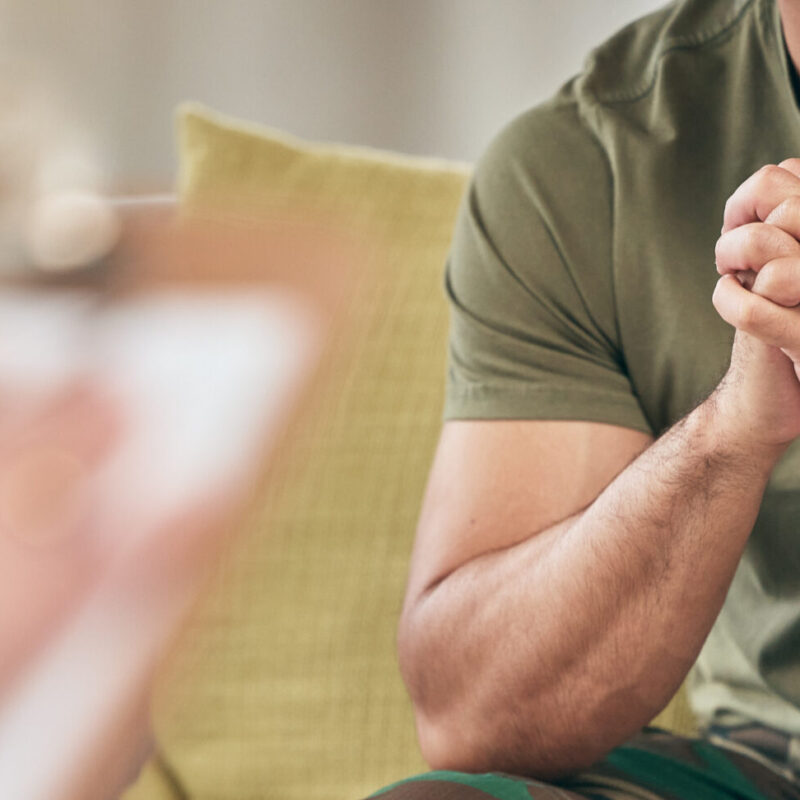 Military Man hands clasped sitting in front of therapist