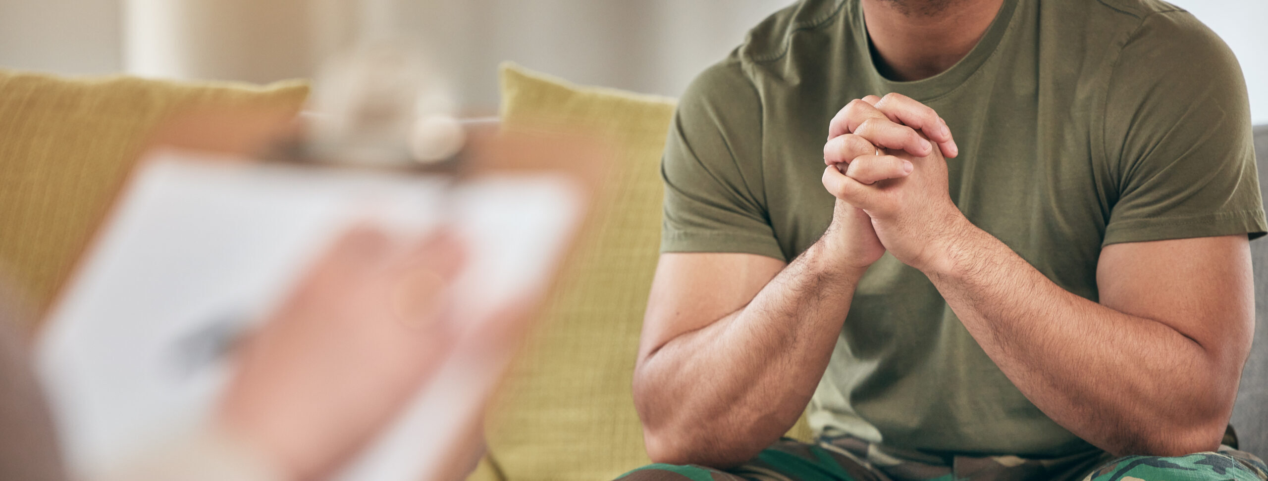 Military Man hands clasped sitting in front of therapist