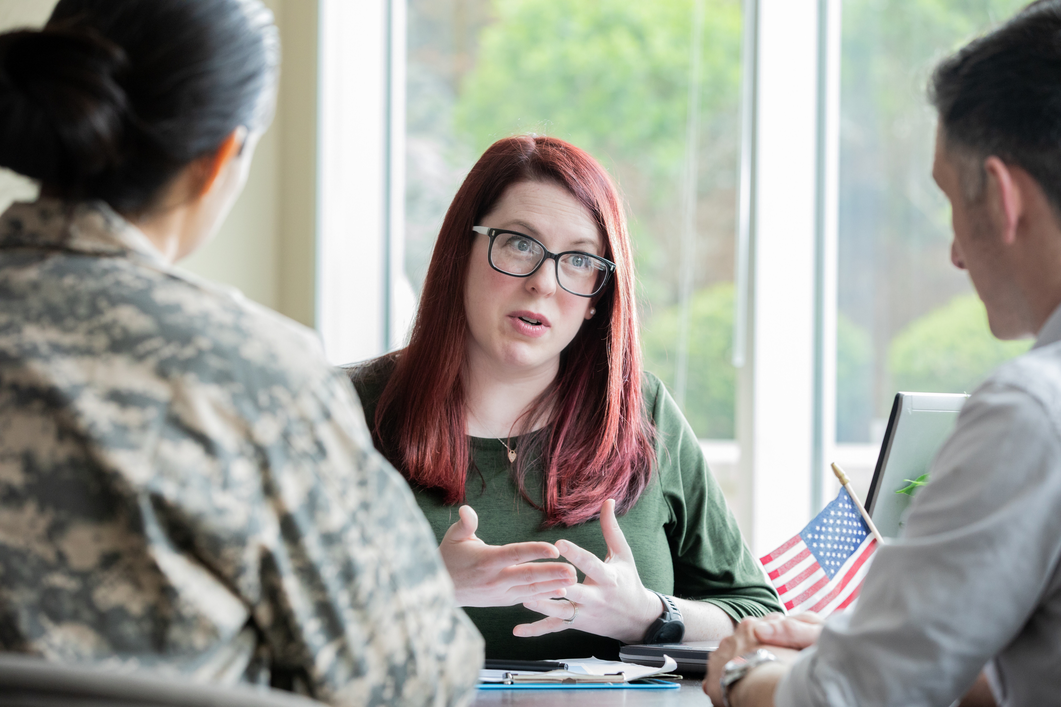 Female financial planner speaking to military couple.