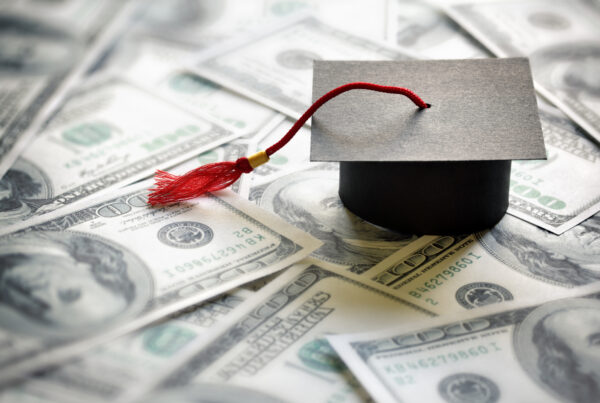 graduation cap on top of one-hundred dollar bills