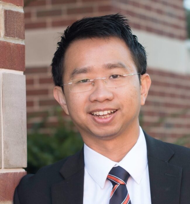 Image of Dr. Kevin Tan, presenter, an Asian man standing outside wearing a suit with an orange and blue tie