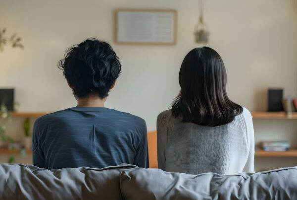 two people sitting on a couch with their backs to the camera