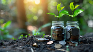 Coins in clear jars on the ground. Symbolizing money in the soil. Sunlight peaking through the trees in the background