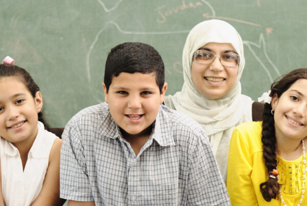 Three students and their teacher in a school classroom