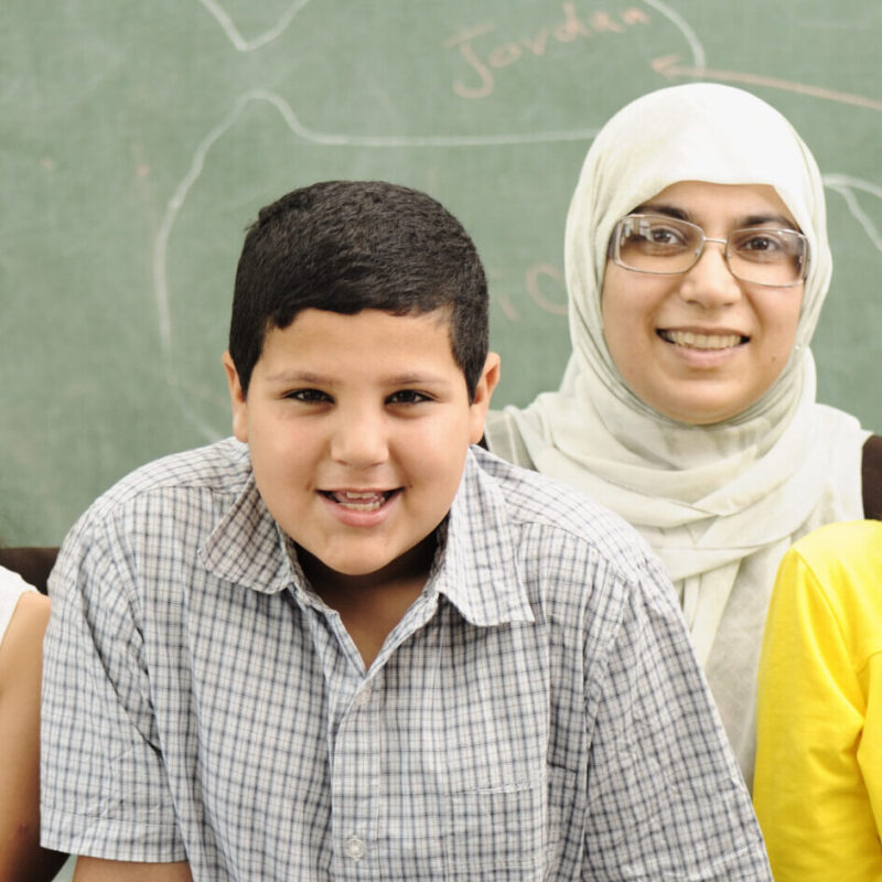 Three students and their teacher in a school classroom