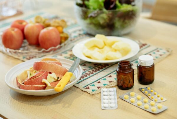 Apple slices and apple peels on plate next to prescription medicine.