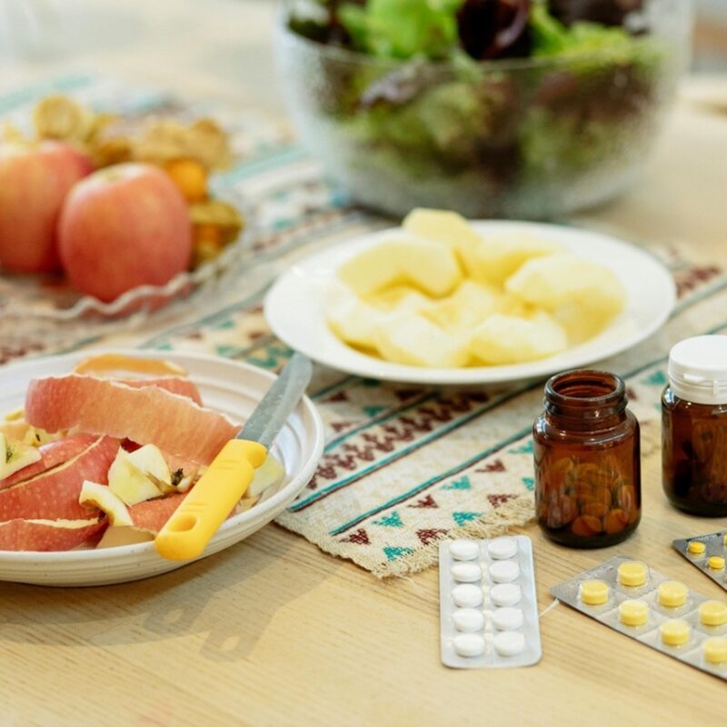 Apple slices and apple peels on plate next to prescription medicine.