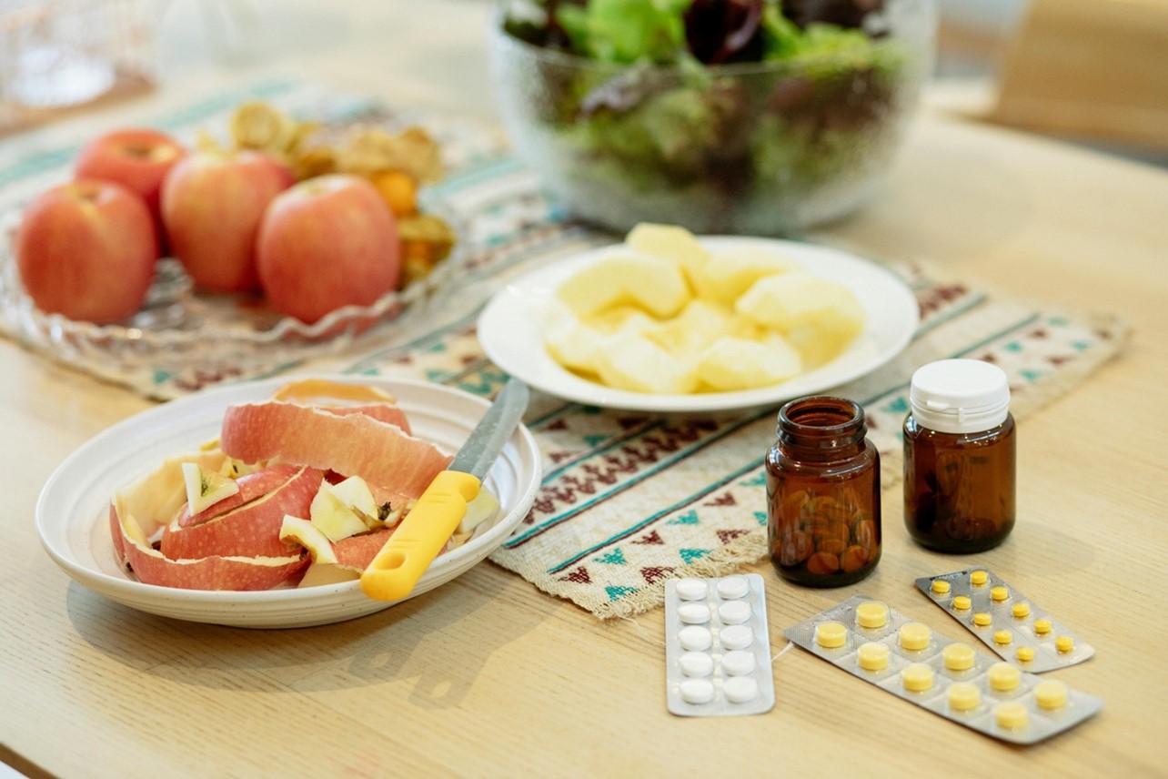 Apple slices and apple peels on plate next to prescription medicine.