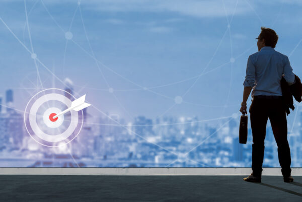 Male holding briefcase looks out over the city, ready to conquer his mission.