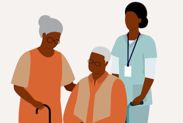 Black Senior Wife With Her Disabled Senior Husband In Wheelchair Is Being Taken Care By A Female Nurse. Isolated On Color Background.