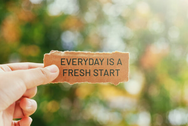 Inspirational life quotes - Everyday is a fresh start written on paper held between two fingers with a bright greenery background