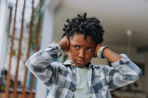 Child with autism covering his ear with his hands