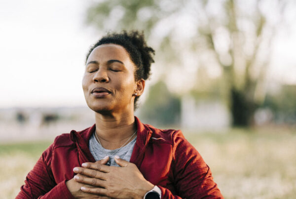 Black woman, breath and hand on chest, for meditation and wellness being peaceful to relax. Bokeh, African American female and lady outdoor, in nature and being calm for breathing exercise and health