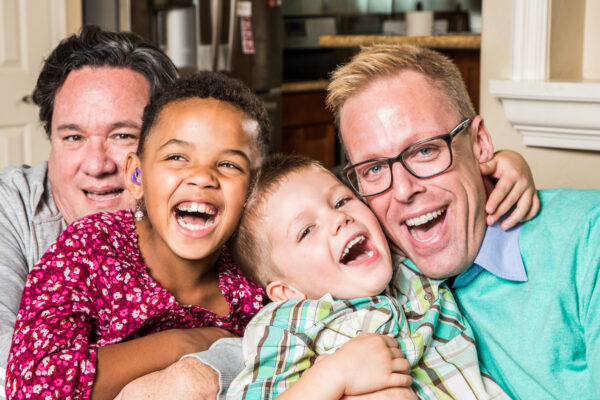 Parents and their children pose for a photo at home