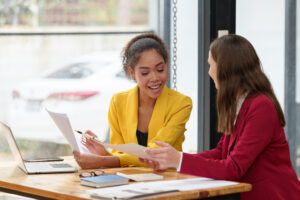 Two women in counseling Doing paperwork sitting in a modern office in a meeting