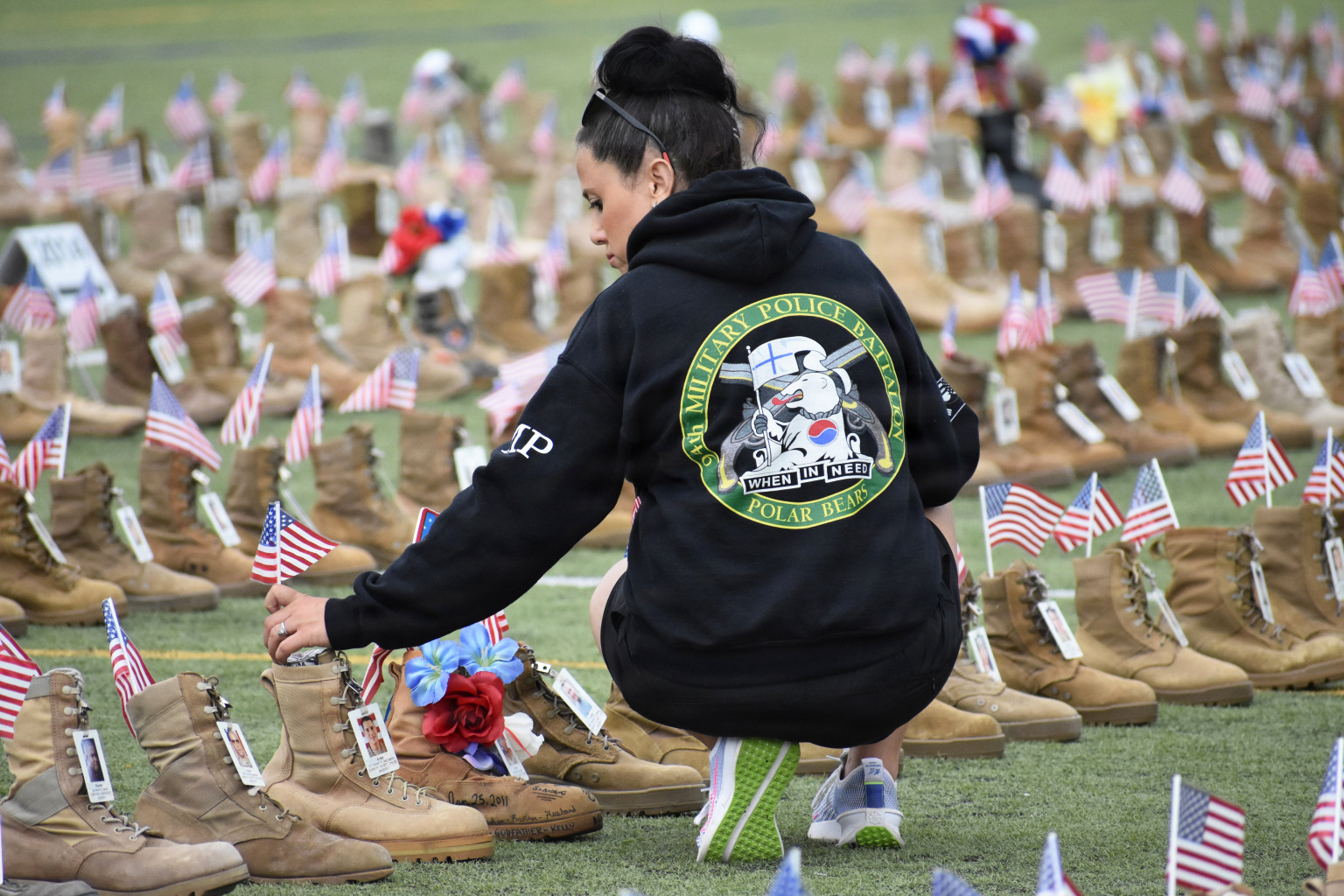 spouse kneeling and putting flag in service member boot