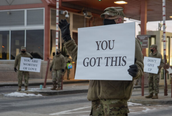 non-commissioned officer-in-charge of cyber security, participates in the “Don’t Give Up” suicide prevention event by holding up a sign and greeting incoming personnel at the Peterson Air Force Base Main Gate, Dec. 18, 2020. The event was held to ensure personnel know they are not alone during this upcoming holiday season.